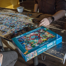 Load image into Gallery viewer, Person working on a puzzle with a completed section and Ravensburger puzzle box on a table.