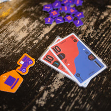 Load image into Gallery viewer, Close-up of playing cards and game pieces on a wooden surface