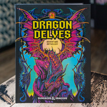 Load image into Gallery viewer, The front cover of the 'Dragon Delves' Dungeon Masters Anthology, featuring a vibrant, colorful illustration of a dragon in shades of pink, purple, and blue on a black background. The title 'DRAGON DELVES' is written in bold yellow letters, and 'DUNGEONS & DRAGONS' is visible at the bottom.