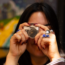 Load image into Gallery viewer, Person holding a vintage camera lens up to their eye with a blurred background
