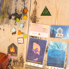 Load image into Gallery viewer, Collection of National Park-themed cards and stickers on a wooden surface
