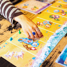 Load image into Gallery viewer, Hand playing a board game with colorful cards on a wooden table
