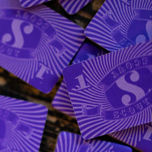 Load image into Gallery viewer, Purple playing cards with a logo on a textured surface
