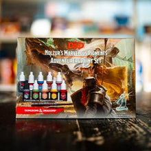 Load image into Gallery viewer, D&amp;D Nolzur's Marvelous Pigments Adventurer's Paint Set packaging on a wooden surface.
